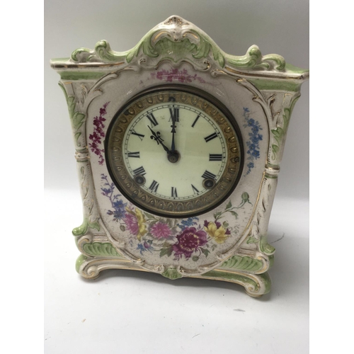 966 - A Edwardian mantel clock with pottery floral case the circular dial with Roman numerals.