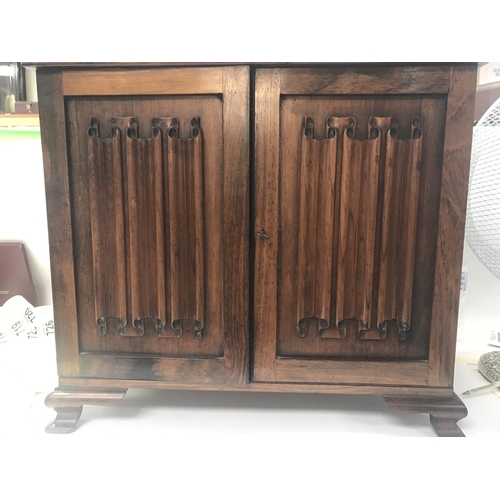 717 - A small mahogany cabinet the pair of carved doors enclosing five drawers And open sections.