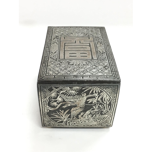 738 - An Oriental white metal and bronzed box with stag, roe and bird decoration to side panels and push b... 