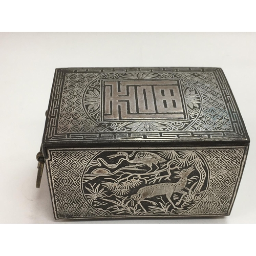 738 - An Oriental white metal and bronzed box with stag, roe and bird decoration to side panels and push b... 