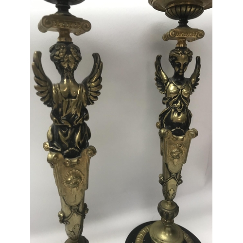 746 - A pair of Empire style candle sticks in the form of classical figures on circular bases on claw feet... 