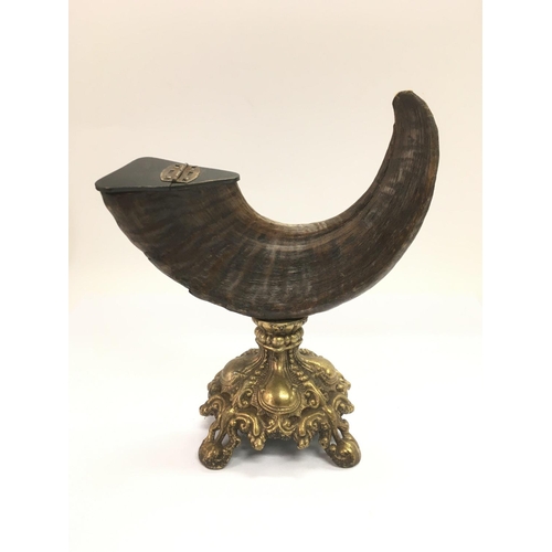 772 - An old ram's horn snuff mull raised on an ornate brass base, approx height 22cm.