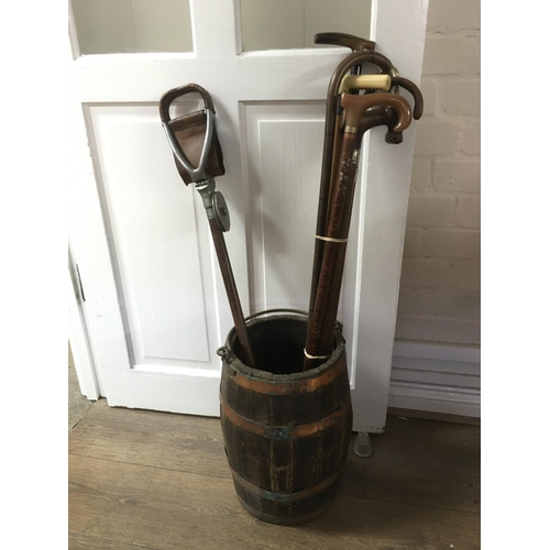 778 - An old wooden barrel stick stand containing a Victorian ladies walking cane with silver band and hor... 