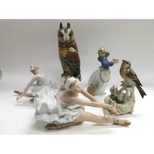 843 - A German ceramic figure of an owl, two ballerina figures, Nao girl and a figural group of nesting bi... 