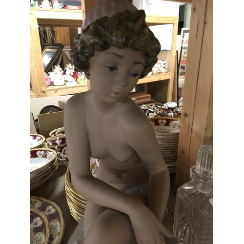 850 - A Lladro figure of a semi nude girl seated upon a rock .48 cm