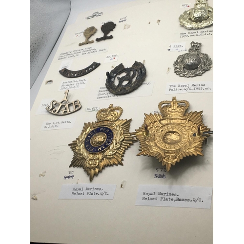 2020 - An album containing military badges British Colonials Marines and others including some helmet plate... 