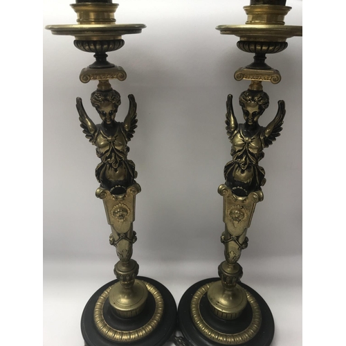 755 - A pair of Empire style candle sticks in the form of classical figures on circular bases on claw feet... 