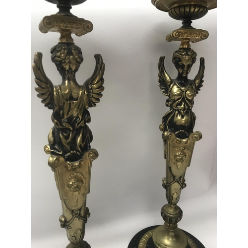 755 - A pair of Empire style candle sticks in the form of classical figures on circular bases on claw feet... 