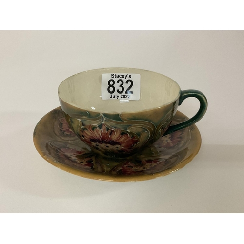 853 - A Moorcroft Pottery Cornflower design cup and saucer. (Some damage).