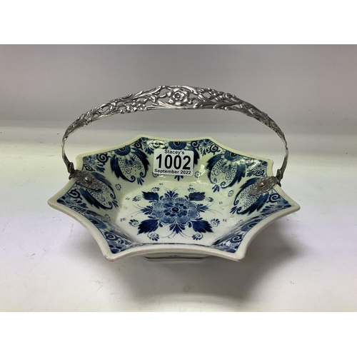 1002 - A small delft pottery tin glaze bowl with a white metal handle.