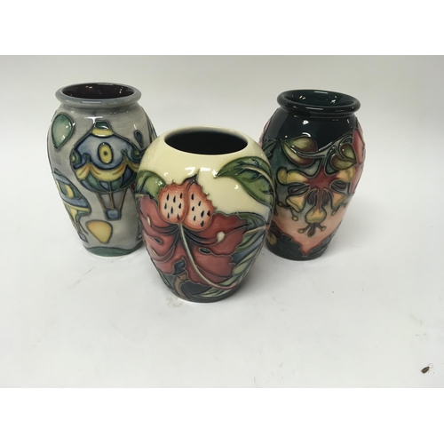 1012 - Three Moorcroft vases decorated with flowers and foliage and hot air balloons.9.5 cm and 11 cm