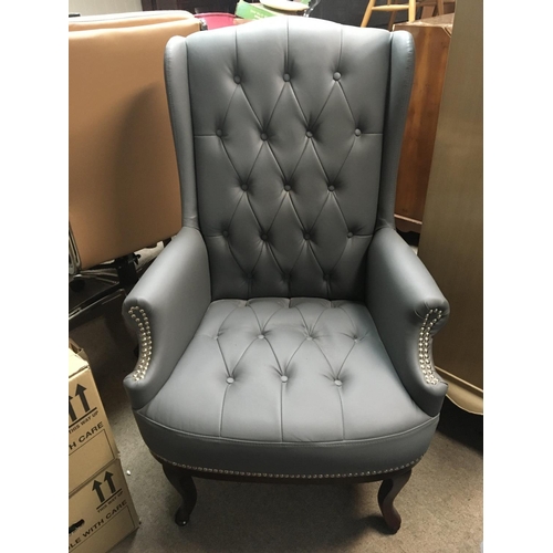 1311 - A leather upholstered wing arm chair with cabriole legs.