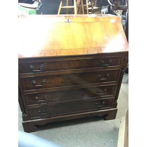 1314 - A Yew wood bureau with a well fitted interior above four graduating drawers.