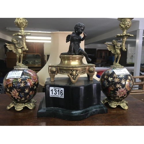 1316 - A pair of cherub candle sticks and a bronze cherub on a  marble simulated Base .