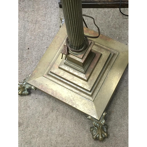 1320 - A brass standard lamp the column on square base on claw feet .