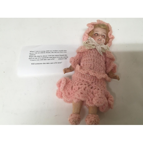 2055 - An early 20th century bisque head doll with a vendors note.