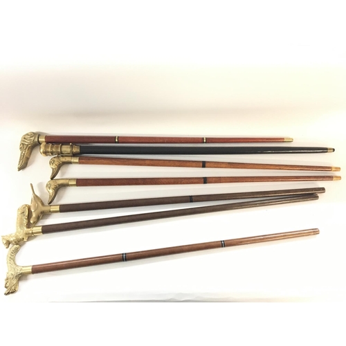 2076 - A collection of seven brass topped walking sticks.