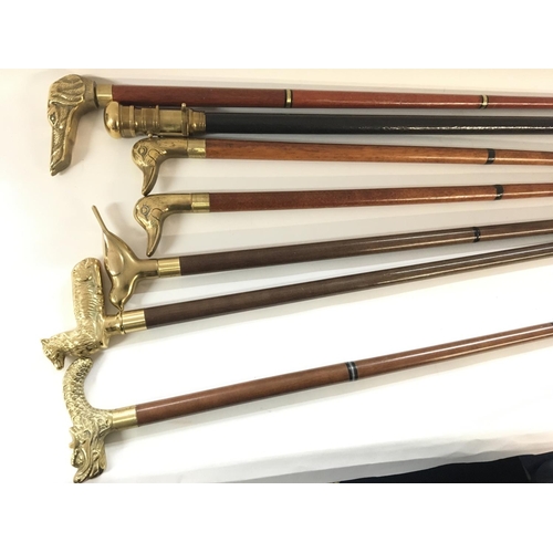 2076 - A collection of seven brass topped walking sticks.