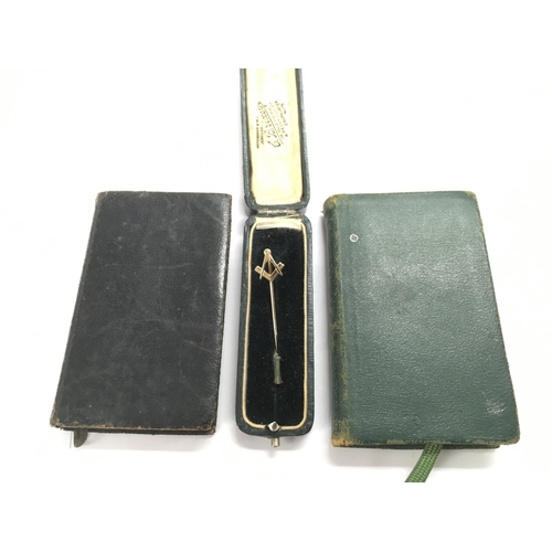 704 - A cased Masonic tie pin and two miniature Masonic books.