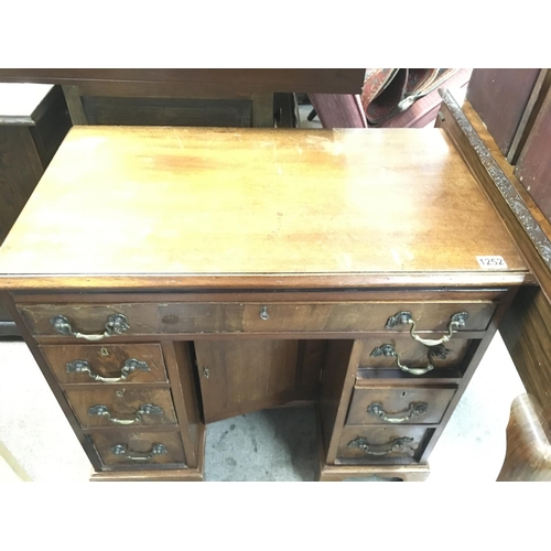 1252 - A mahogany kneehole desk fitted with nine drawers central cupboard door 
On ogee bracket feet . 76 c... 