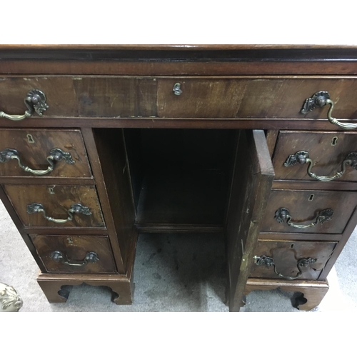 1252 - A mahogany kneehole desk fitted with nine drawers central cupboard door 
On ogee bracket feet . 76 c... 