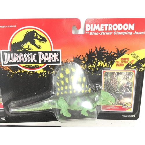 57 - 2 Carded Jurassic Park Figures and a sealed Annual. Including A Velociraptor and a Dimetrodon.