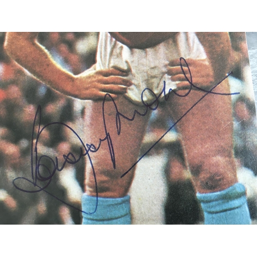 605 - Bobby Moore West Ham Signed Football Picture: Large size colour magazine picture of Moore in West Ha... 