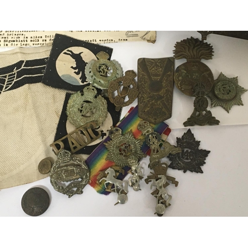 2103 - A German Third Reich cloth badge and a collection of British military cap badges including First Wor... 