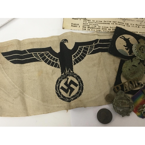 2103 - A German Third Reich cloth badge and a collection of British military cap badges including First Wor... 