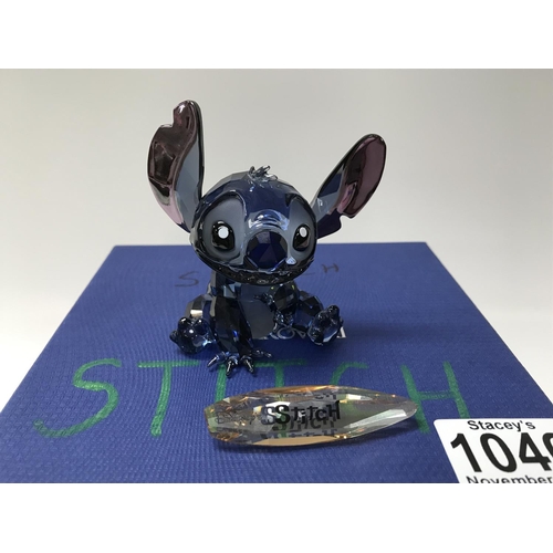 1046 - A Disney Swarovski Crystal figure of Stitch complete with box and name bar. ( 1 finger missing).