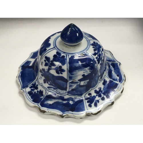 1140 - A Kangxi blue and white lid decorated with landscape views. 16cm across