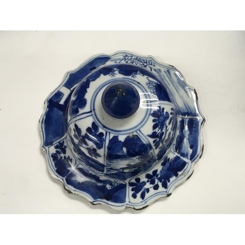 1140 - A Kangxi blue and white lid decorated with landscape views. 16cm across