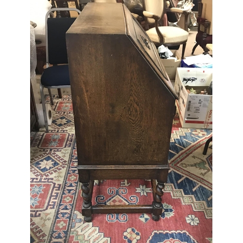 1314 - An oak bureau with a full front fitted interior Barley twist legs