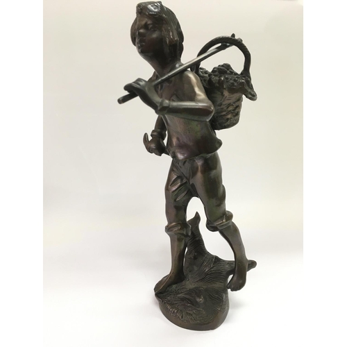 704 - A bronze figure of a farmworker carrying a basket laden with berries, approx height 34.5cm.