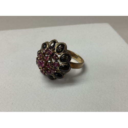 734 - An 18ct gold ruby and black stone set dress ring. Size O.