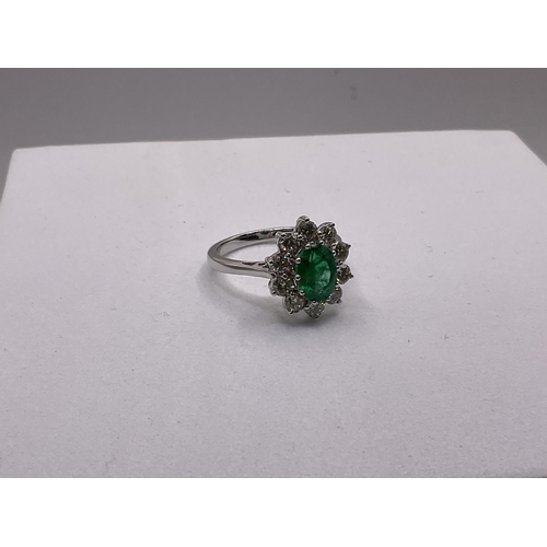 774 - A certified 18ct white gold oval emerald and diamond cluster ring, emerald 1.20ct, Diamonds 1.00ct.