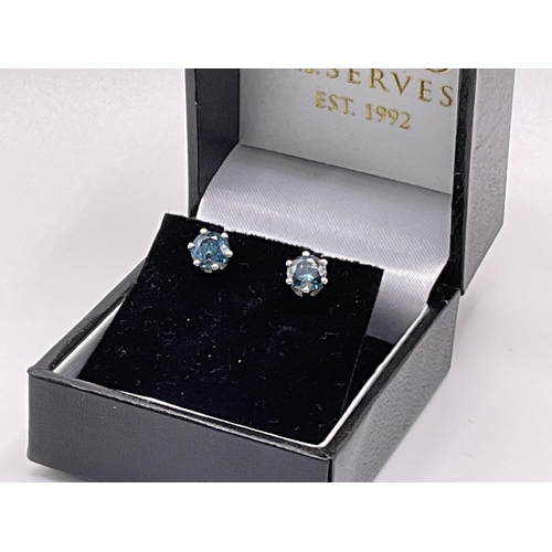 781 - A pair of 14ct gold solitaire ear studs set with 1.52ct treated fancy blue RBC diamonds.