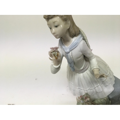 957 - A Lladro figure of a young girl holding flowers height 29cm.