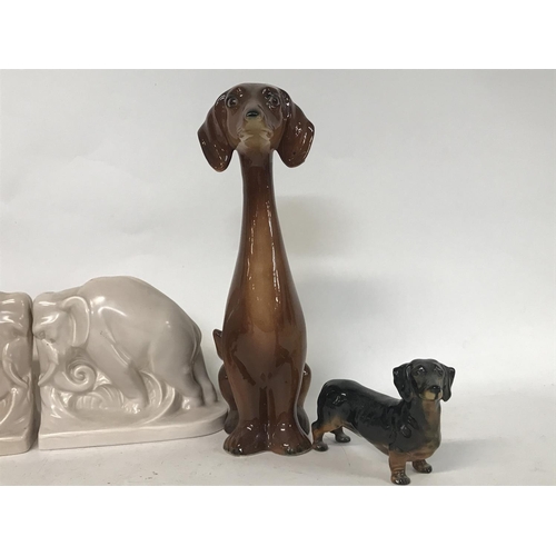 1133 - Pair of pottery elephant book ends, a Beswick pigeon, a Doulton character jug- The Poacher and dog o... 