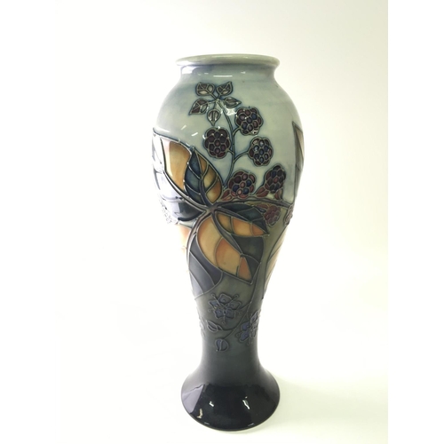 1173 - A Moorcroft vase decorated with Berries and leaves. tube line decorated. No damage Hight 28cm