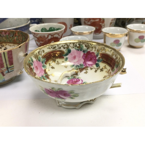 1255 - A collection of Oriental cups, saucers and dishes.