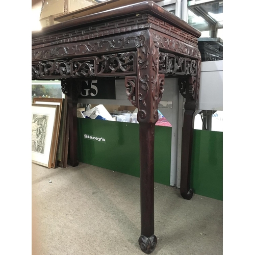 1398 - A Chinese side table inset with Rose Marble, with carved and scrolled folate decoration. 87cm x 46cm... 