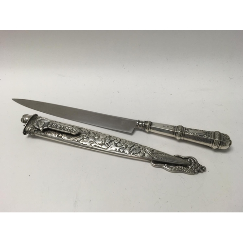 808 - An Ornate silver plated dagger with Inox blade and sheath. Overall length 31cm.