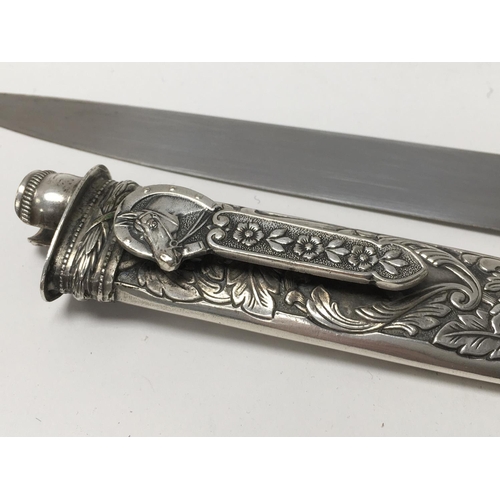 808 - An Ornate silver plated dagger with Inox blade and sheath. Overall length 31cm.