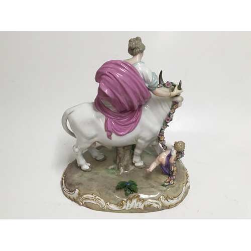 930 - An early 19thC Meissen porcelain figure of a maiden riding a bull. 26cm. Blue crossed swords mark to... 