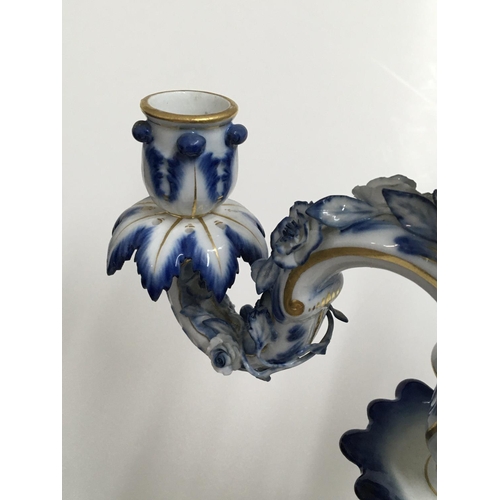 932 - A pair of Meissen candelabra with blue, white and gilt decoration o mounted with putti. 50cm. (Some ... 