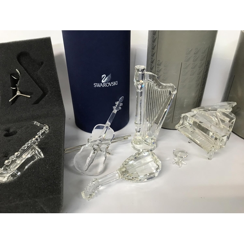 940 - Five boxed Swarovski pieces including Violin, Saxophone, Grand Piano and Stool, Harp and Lute plus s... 