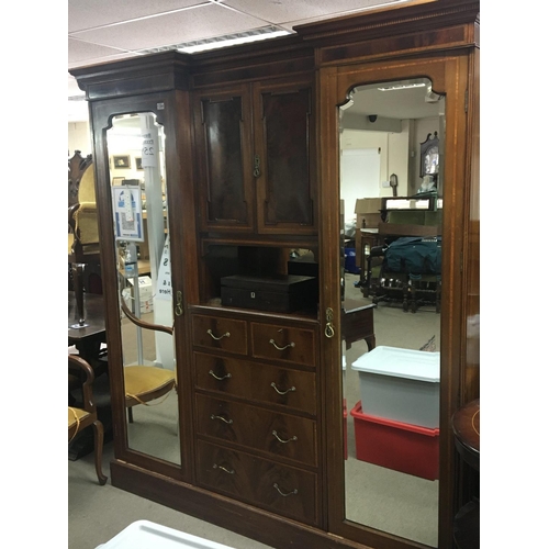 201 - An Edwardian inlaid Mahogany wardrobe with bevelled edge doors the centre section with drawers and c... 