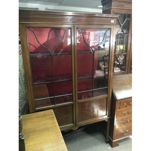 212 - An Edwardian inlaid Mahogany display cabinet with a pair of three quarter glazed doors on square tap... 