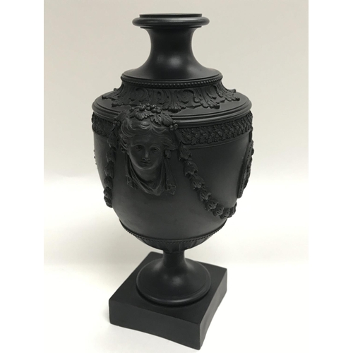 323 - A Neale or Hanley black basalt urn with classical design, restoration to column. 22cm.